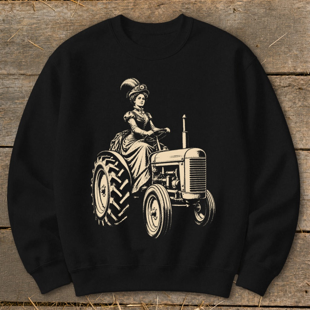 Vintage woman in a hat driving a tractor graphic on a black sweatshirt.