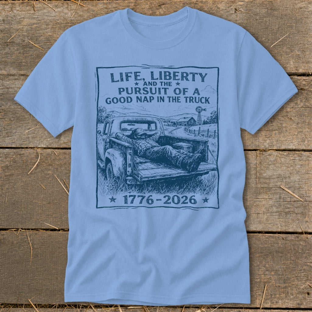 Light blue t-shirt with sketch of man napping in truck bed and text "Life, Liberty and the Pursuit of a Good Nap in the Truck".