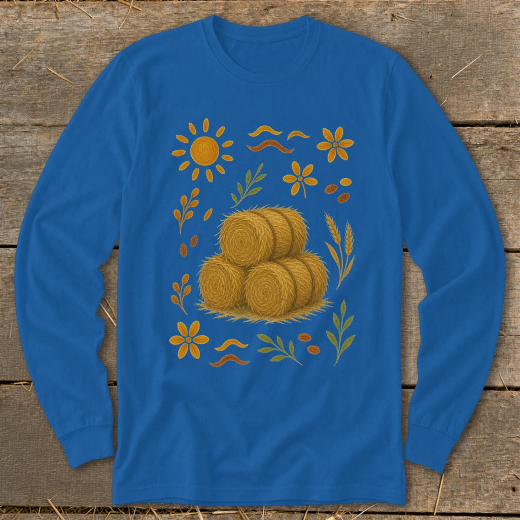 Blue long-sleeve shirt with a central stack of hay bales and autumn-themed illustrations.