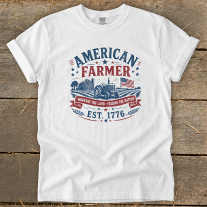 White t-shirt with "American Farmer" graphic, tractor, barn, and American flag.