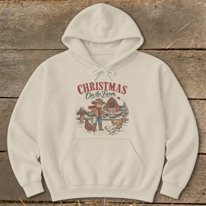 Cream hoodie with "Christmas On the Farm" graphic of boy, barn, and chickens.