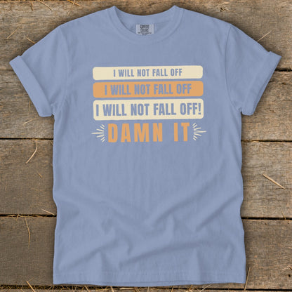 Light blue t-shirt with "I WILL NOT FALL OFF" repeated three times and "DAMN IT".