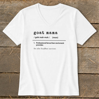 A white V-neck t-shirt featuring the text "goat mama" styled like a dictionary definition on a rustic wooden background.