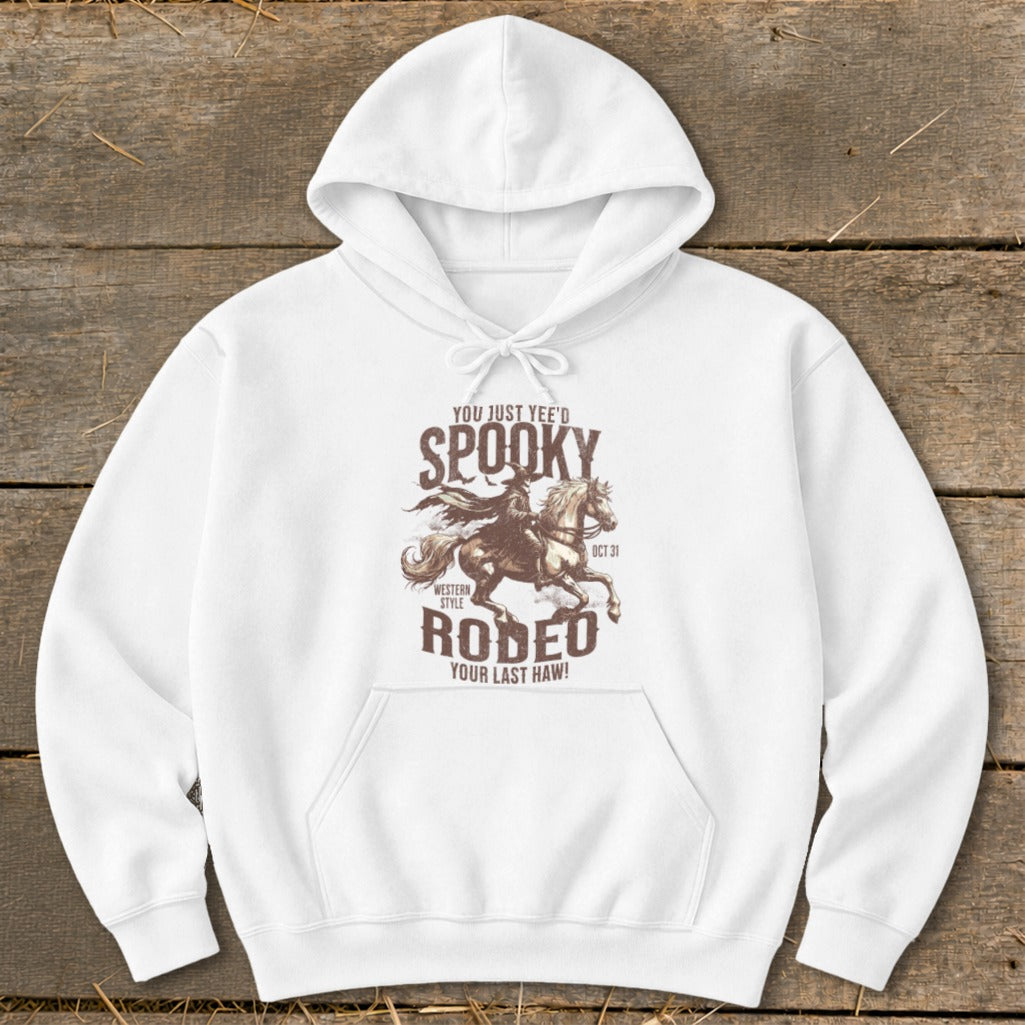 White hoodie with "Spooky Rodeo" graphic featuring a cowboy on a horse and October 31st.
