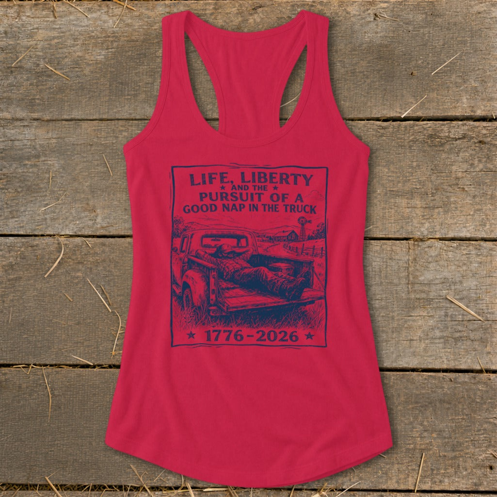 Red tank top with dark blue graphic: "Life, Liberty and the Pursuit of a Good Nap in the Truck 1776-2026."