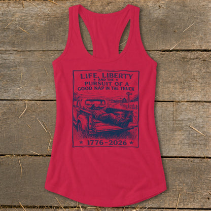 Red tank top with dark blue graphic: "Life, Liberty and the Pursuit of a Good Nap in the Truck 1776-2026."