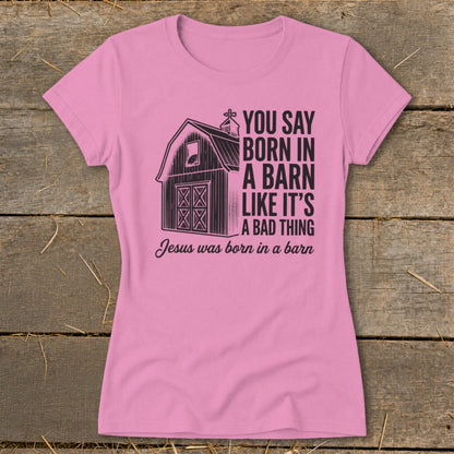 Pink t-shirt with barn graphic and text "Jesus was born in a barn".