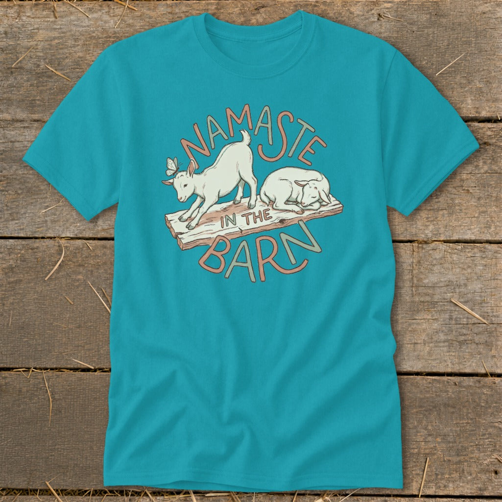 Teal t-shirt with "Namaste in the Barn" text and two goats on a wooden plank.