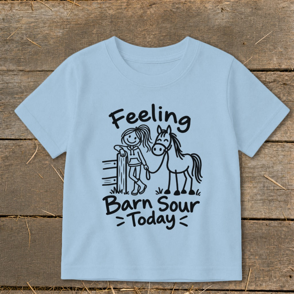 Light blue t-shirt with black text and drawing of girl with horse.