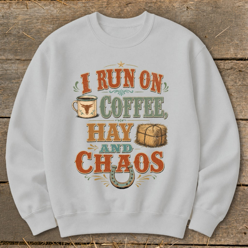 White sweatshirt with "I run on coffee, hay and chaos" text and western graphics.
