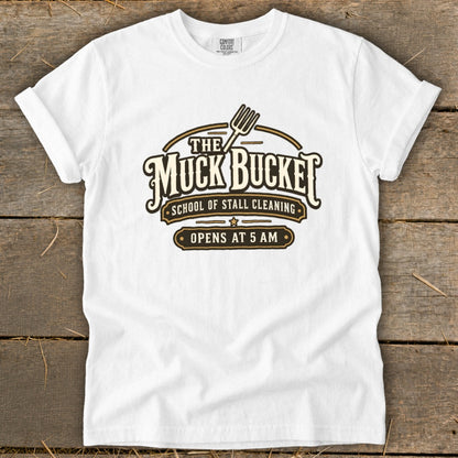 White t-shirt with "The Muck Bucket" and "Opens at 5 AM" graphic.