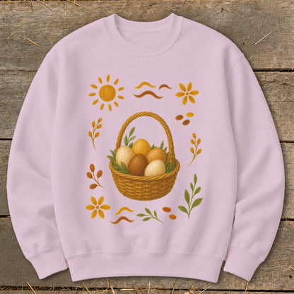 Pink sweatshirt with a woven basket of eggs and decorative floral elements.