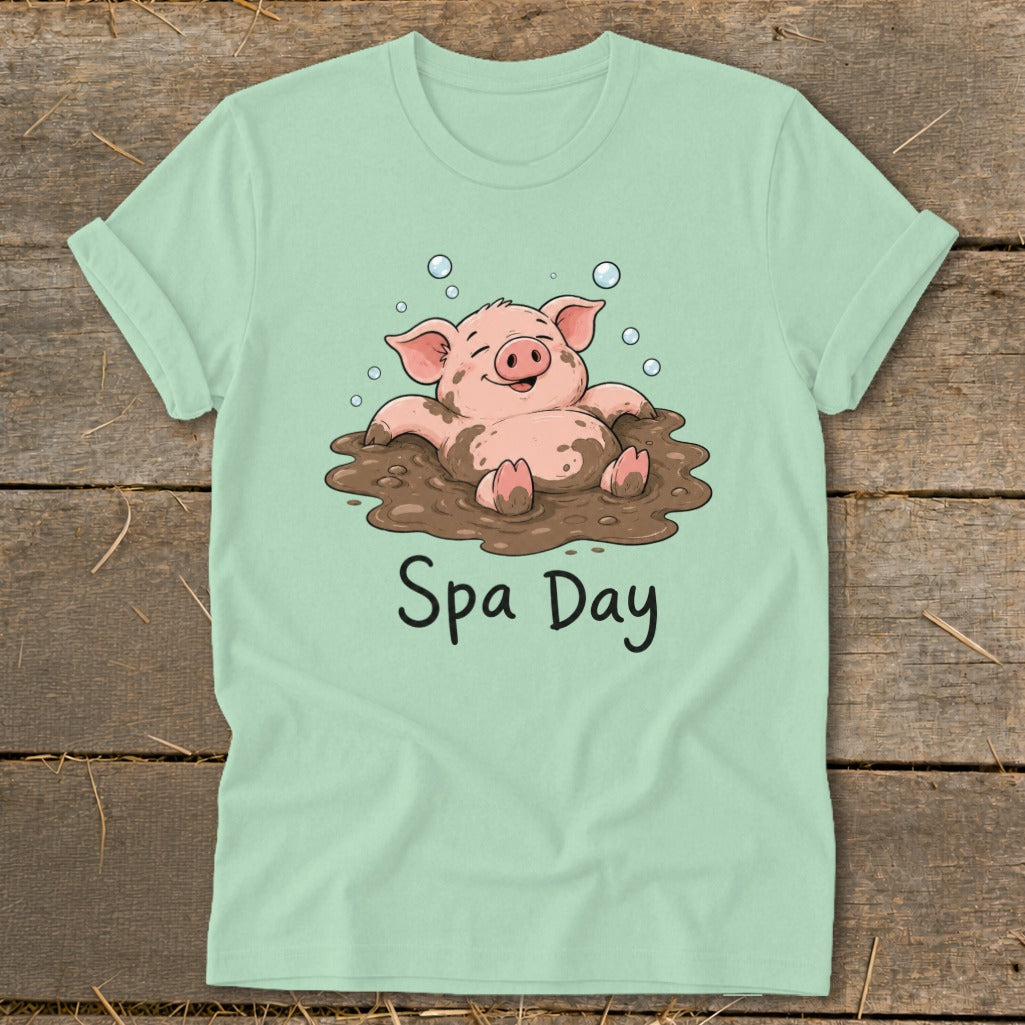 Light green t-shirt with cartoon pig enjoying a mud bath, text "Spa Day".