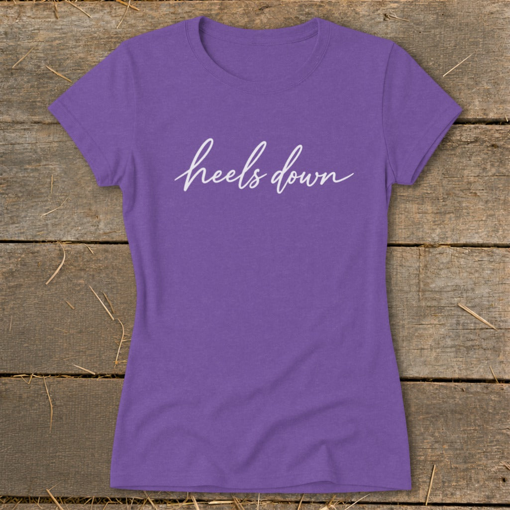 Purple t-shirt with "heels down" in white cursive text.