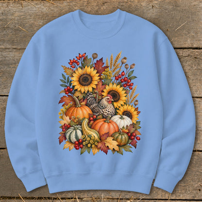 Light blue sweatshirt with a watercolor design of sunflowers, pumpkins, chicken, and fall leaves.