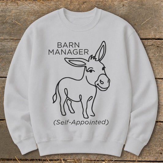 White sweatshirt with black text and outline drawing of a donkey: "BARN MANAGER (Self-Appointed)".