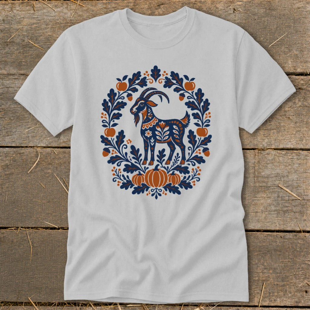 A light gray t-shirt featuring a folk art goat surrounded by an autumn wreath.