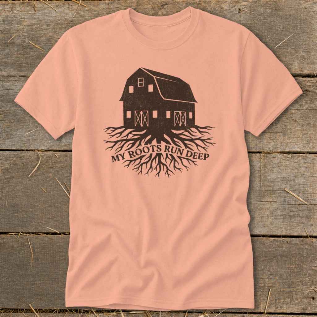 Peach t-shirt with a dark brown graphic of a barn with roots and text "MY ROOTS RUN DEEP".