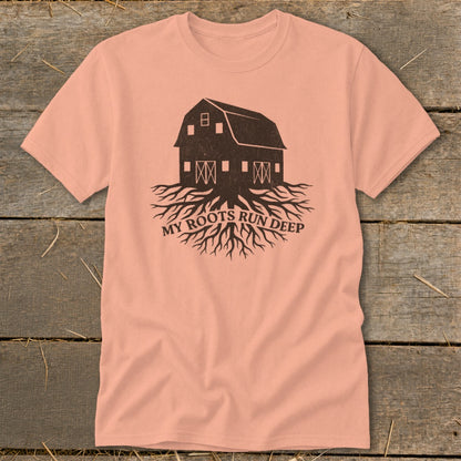 Peach t-shirt with a dark brown graphic of a barn with roots and text "MY ROOTS RUN DEEP".