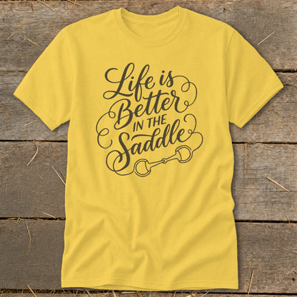 Yellow t-shirt with "Life is Better IN THE Saddle" and horse bit graphic.