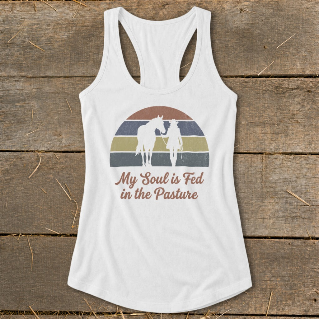 White tank top with horse and rider silhouette, "My Soul is Fed in the Pasture" text.