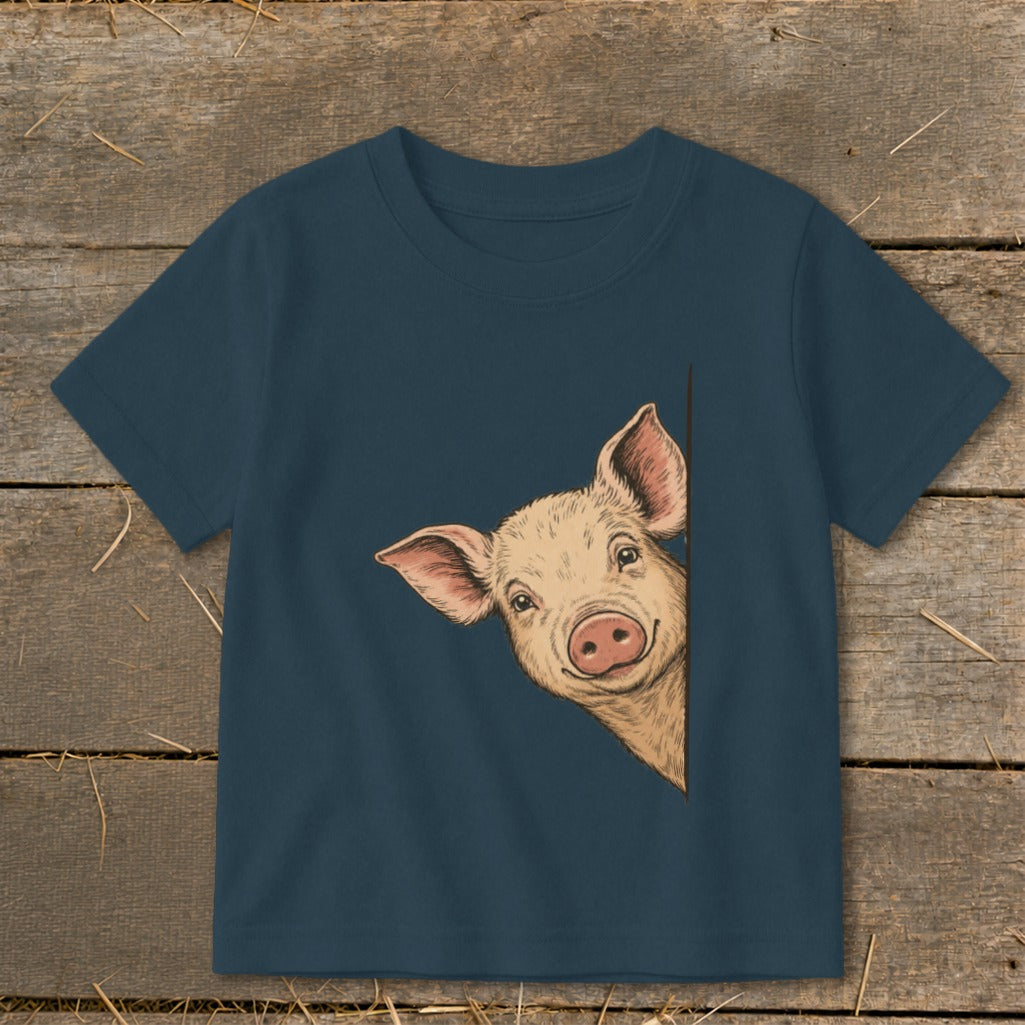 Close-up of a navy t-shirt with a drawing of a pig peeking from the side.