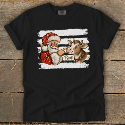 Santa booping a cow's nose with the word "Boop" on a t-shirt.