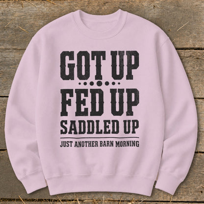 Pink sweatshirt with black text reading "GOT UP FED UP SADDLED UP JUST ANOTHER BARN MORNING".