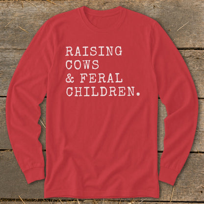 Red long-sleeve shirt with white text: "Raising Cows & Feral Children."