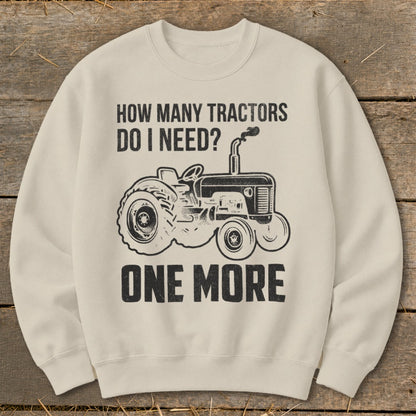 Cream sweatshirt with black tractor graphic and text: "How many tractors do I need? One more."