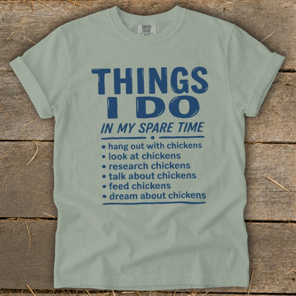 Light green t-shirt with blue text listing chicken-related activities.