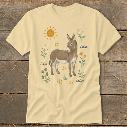 Light yellow t-shirt with a donkey surrounded by flowers, sun, and wavy lines.