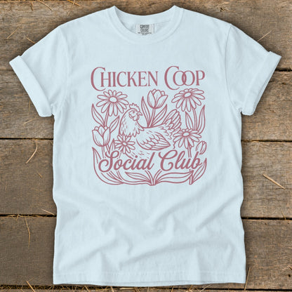 White t-shirt with "CHICKEN COOP SOCIAL CLUB" text and chicken with flowers design.