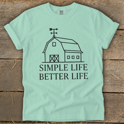Mint green t-shirt with a black line drawing of a barn and the text "SIMPLE LIFE BETTER LIFE".