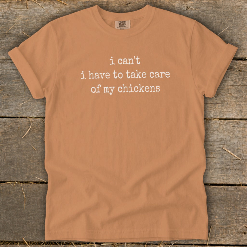 Orange t-shirt with white text "i can't i have to take care of my chickens".