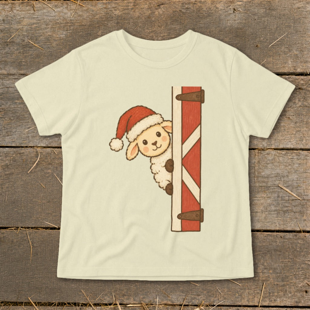 Cream t-shirt with a cartoon sheep wearing a Santa hat peeking from behind a red barn door.