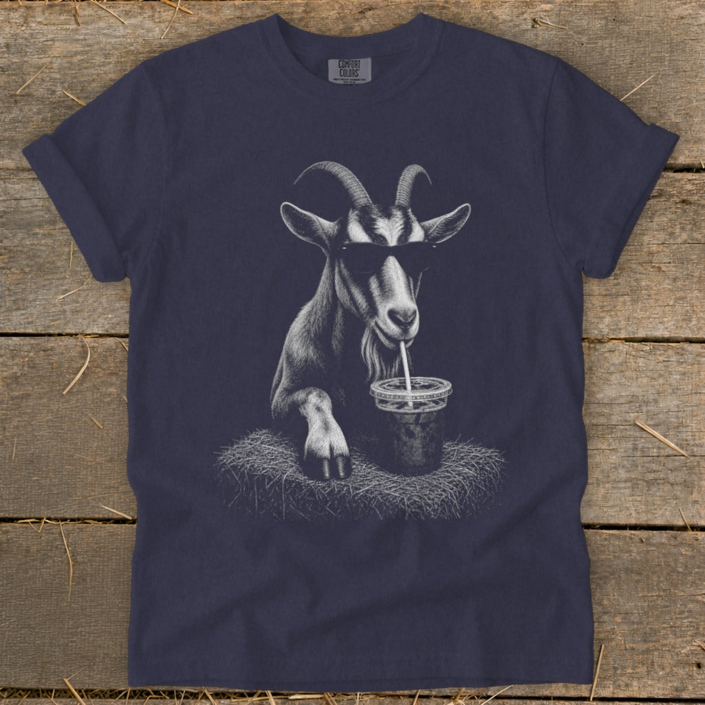 Goat wearing sunglasses sips drink from straw on a bed of hay.