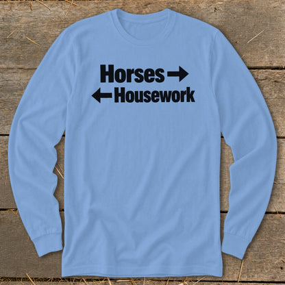 Light blue long-sleeve t-shirt with black text that reads "Horses" with a right arrow above "Housework" with a left arrow.