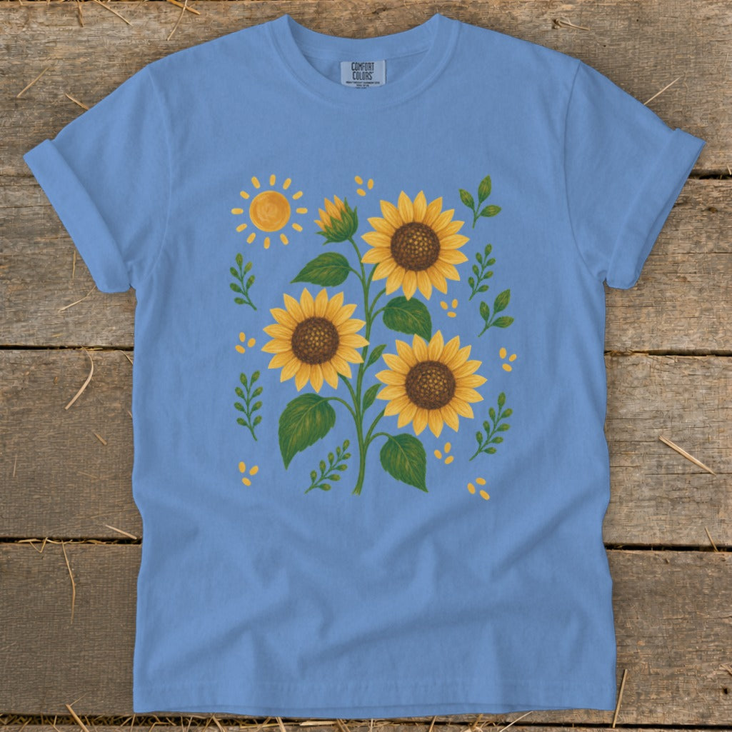 Light blue t-shirt with a sunflower and sun graphic design.