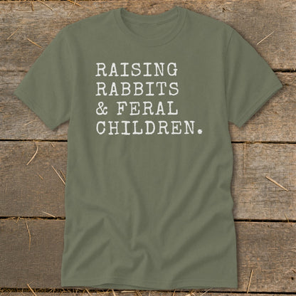Olive green t-shirt with white text reading "RAISING RABBITS & FERAL CHILDREN."