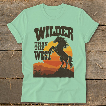 Mint t-shirt with "Wilder Than The West" text and a rearing horse silhouette at sunset.