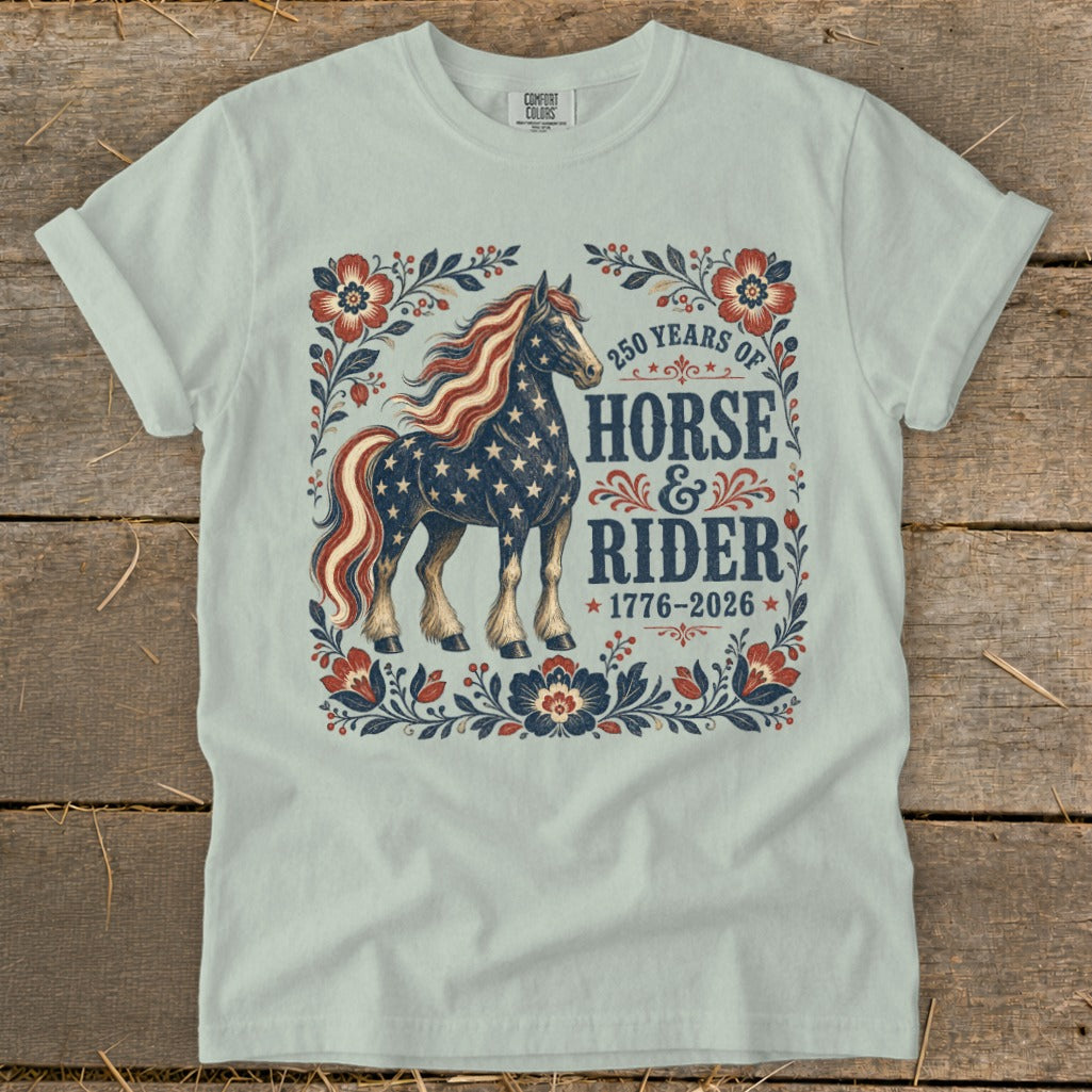 Front of light blue t-shirt with "250 Years of Horse & Rider 1776-2026" text and patriotic horse graphic.