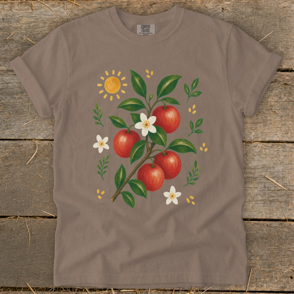 Taupe t-shirt with a painted apple branch, sun, and flowers design.