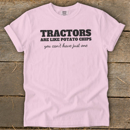 Pink t-shirt with black text that reads "Tractors are like potato chips you can't have just one."