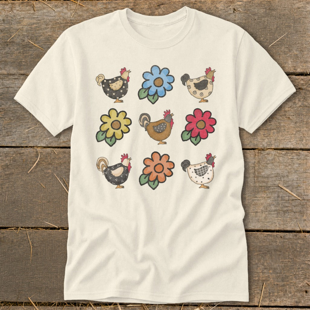 Cream t-shirt with nine watercolor drawings of chickens and flowers in a grid.