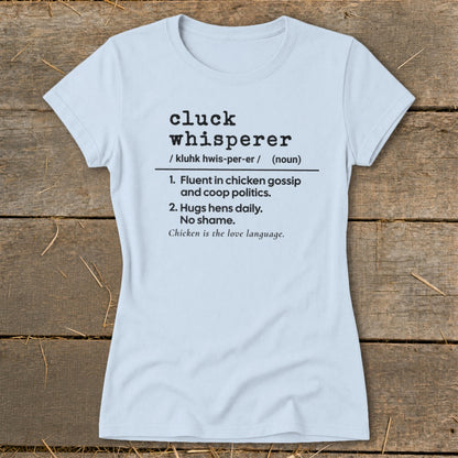 Light blue t-shirt with "Cluck Whisperer" definition and chicken humor.