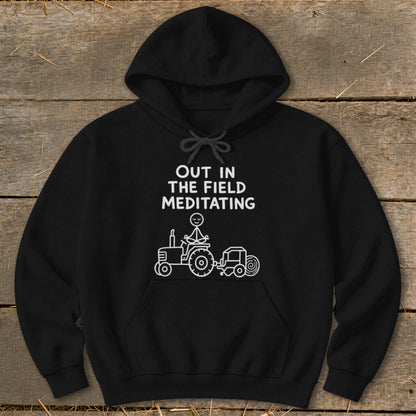 Black hoodie with text "OUT IN THE FIELD MEDITATING" and tractor graphic.