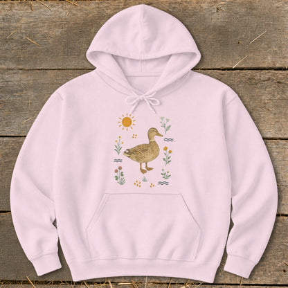 Pink hoodie with a duck illustration surrounded by flowers and a sun.