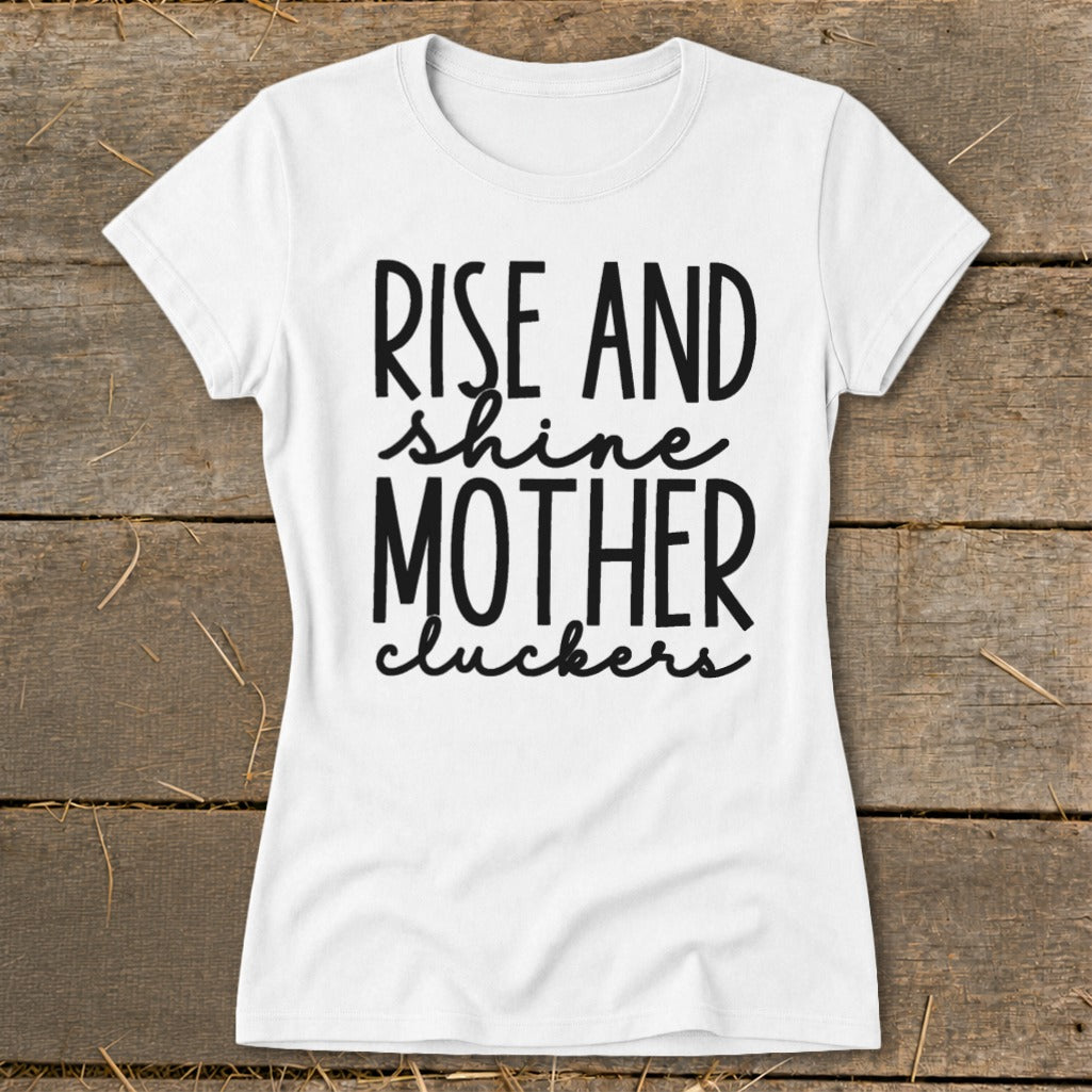 White t-shirt with black text reading "Rise and Shine Mother Cluckers".
