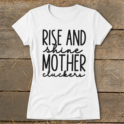 White t-shirt with black text reading "Rise and Shine Mother Cluckers".